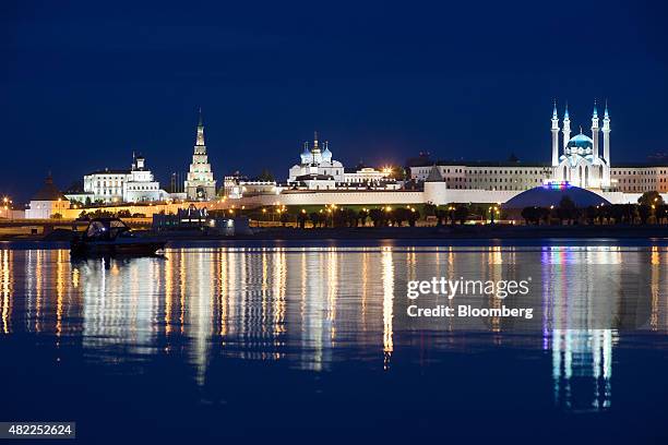 The Kazan Kremlin, center, and Kul Sharif mosque, right, sit illuminated at night beyond the Kazanka river on the city skyline in Kazan, Russia, on...