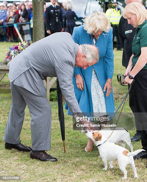 Prince Charles, Prince of Wales and Camilla, Duchess of Cornwall meet some dogs as they attend Sandringham Flower Show at Sandringham on July 29,...