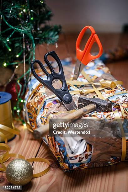 bad packed christmas gift spiked with scissors - bad christmas present stockfoto's en -beelden