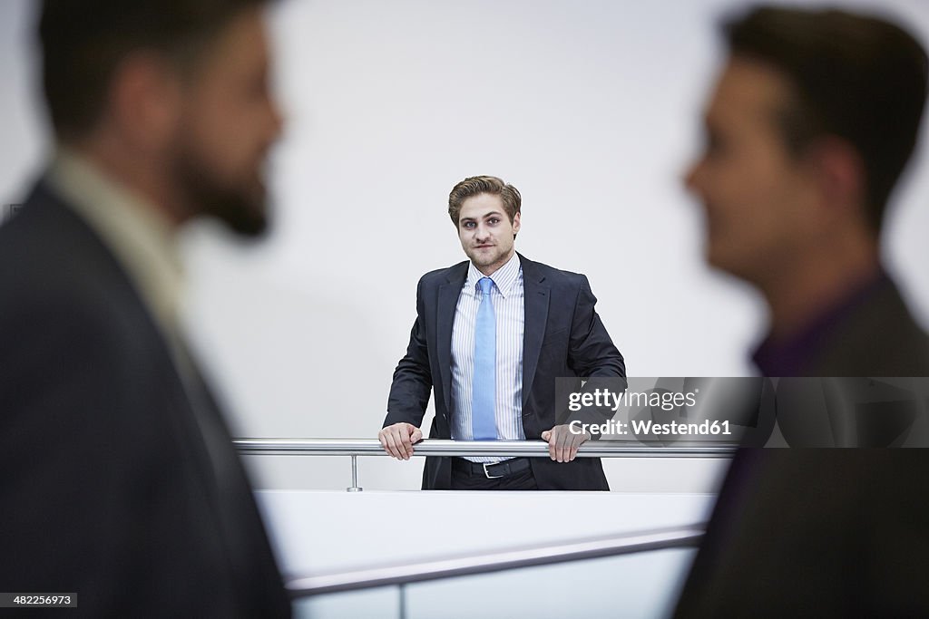 Germany, Neuss, Businessmen talking in corridor