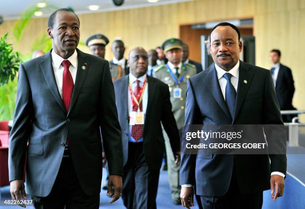 Burkina Faso President Blaise Compaore walks alongside Niger President Mahamadou Issoufou at the end of the 4th EU - Africa Summit of Heads of State...