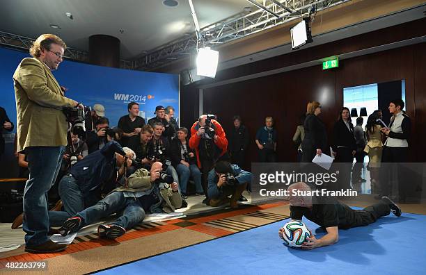 Photgraphers take pictures of the official FIFA match ball during the ARD/ZDF FIFA World Cup 2014 team presentation event on April 3, 2014 in...