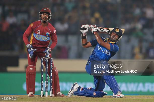 Lahiru Thirimanne of Sri Lanka hits a six, as Denesh Ramdin of the West Indies looks on during the ICC World Twenty20 Bangladesh 2014 Semi Final...