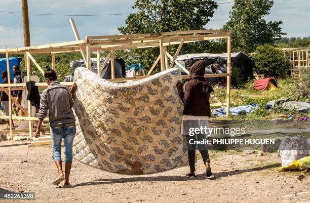 Migrants build a makeshift shelter at a site dubbed the "new jungle", where migrants trying to cross the Channel to reach Britain have camped out...