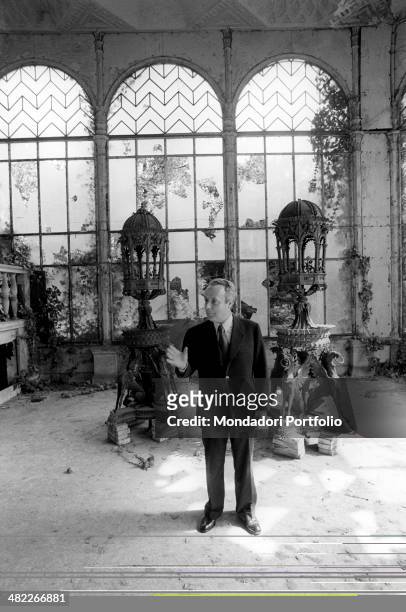 The author of The Garden of the Finzi-Continis Giorgio Bassani, native to Ferrara, in front of two sculptures in the interior of one of the desolates...