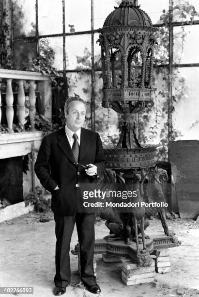 The author of The Garden of the Finzi-Continis Giorgio Bassani, native to Ferrara, poses next to a sculptures in the interior of one of the desolates...