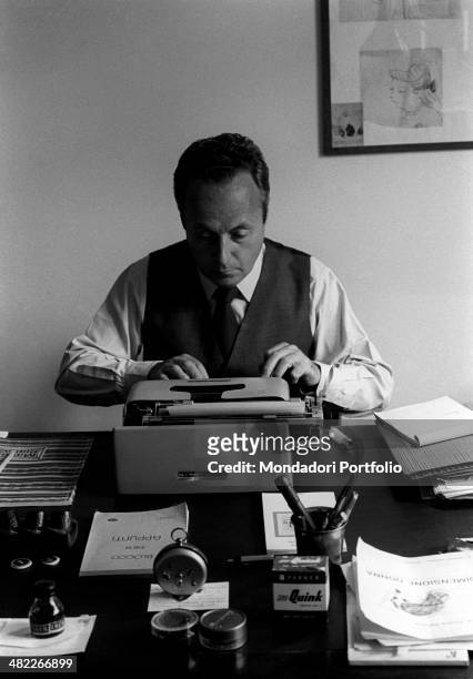 The writer and intellectual Giorgio Bassani sits concentrated at his typewriting; on the table, can be seen a set of pipes, a pencil case and other...