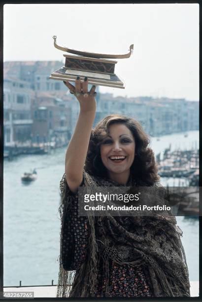 Italian singer Mia Martini raising the Gondola d'Oro prize won at the Mostra Internazionale di Musica Leggera with the song Donna Sola. Venice, 1973