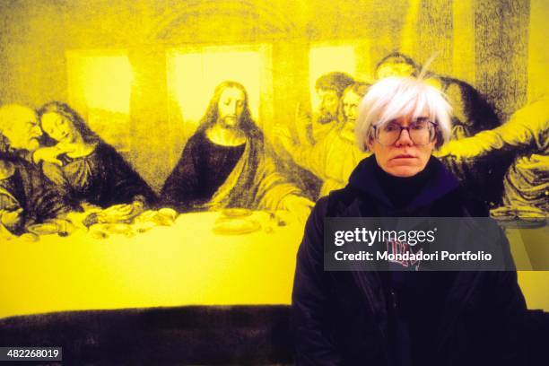 American all-round artist Andy Warhol, icon of the Pop Art Movement, posing seriously in front of The Last Supper, a personal interpretation the...