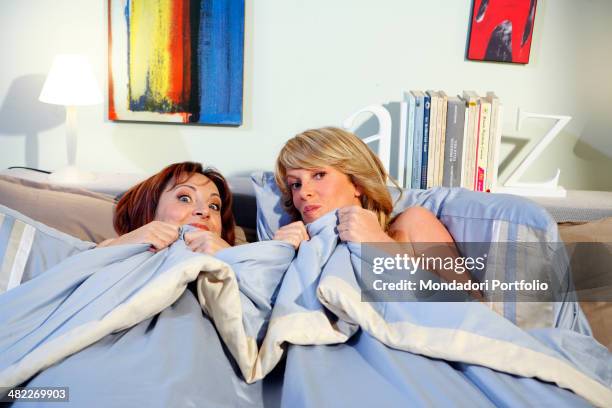 Actresses Alessia Marcuzzi and Debora Villa, both half-dressed, pose under the blanket during a photo shoot on the set of Vous les femmes in 2008 at...