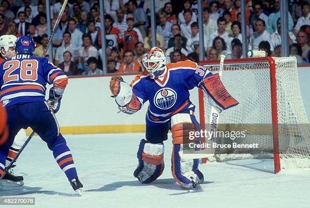 Goalie Grant Fuhr of the Edmonton Oilers makes the glove save during an 1987 Stanley Cup Finals game against the Philadelphia Flyers in May, 1987 at...