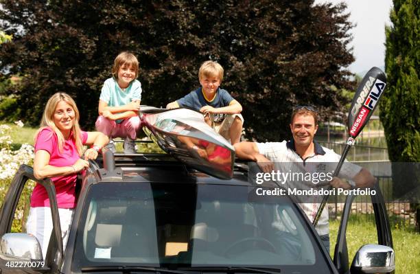 Italian sprint canoer Antonio Rossi, his wife Lucia and their children Riccardo and Angelica pose around the car, carrying the canoe for training,...