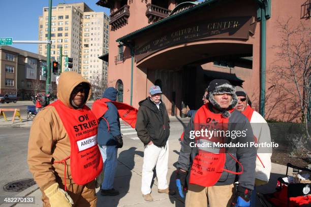 Bunch of workers on strike wearing some red tabards with writings emphasizing their claims; they're member of the International Union of Painters and...