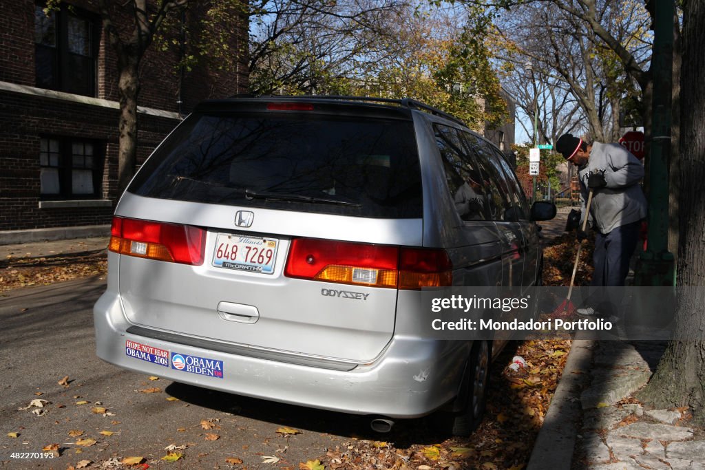 A man sweeps dry leaves in an alley in the Hyde Park district