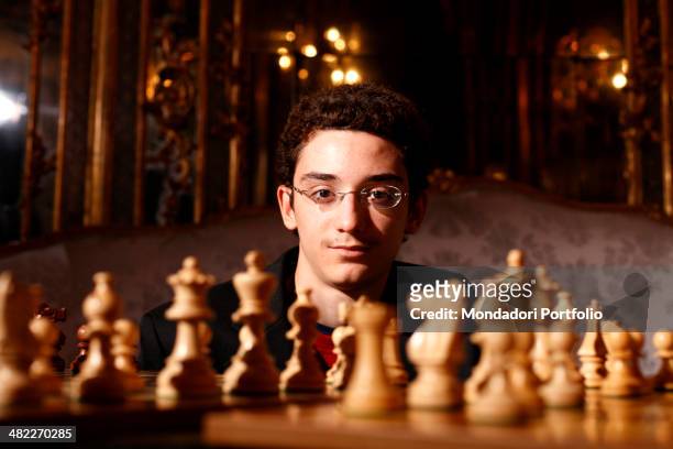 Italo-american Fabiano Caruana, Italian chess champion in office, poses in a close-up, partially hidden behind a chessboard, at the Centro Congressi...