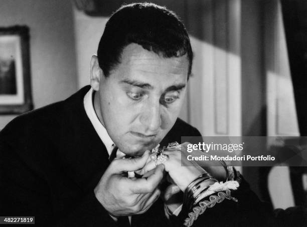 Italian actor Alberto Sordi looking at some rings in the film Piccola posta. 1955