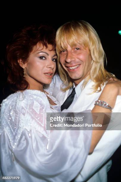 Italian showgirl Carmen Russo and Italian dancer Enzo Paolo Turchi posing hugging on their wedding day. 1987