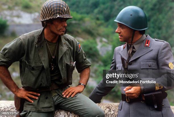 Italian actor Giuliano Gemma and Italian actor and singer Johnny Dorelli playing the role of soldiers acting in the film The Odd Squad. 1982