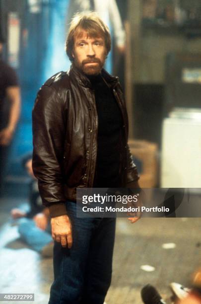American martial artist and actor Chuck Norris wearing a leather jacket acting in the film Code of Silence. 1985