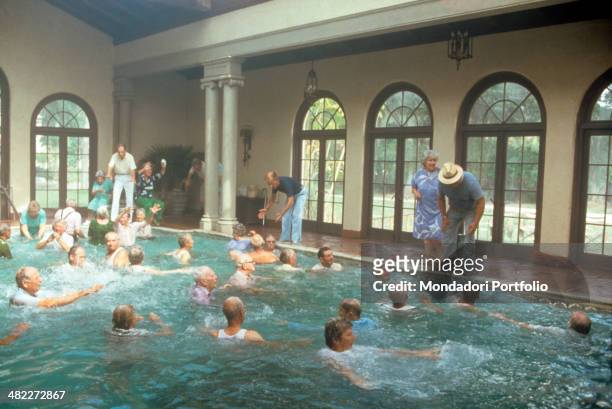 American actors Wilford Brimley, Hume Cronyn and Don Ameche at the edge of a swimming pool acting in the film Cocoon. 1985