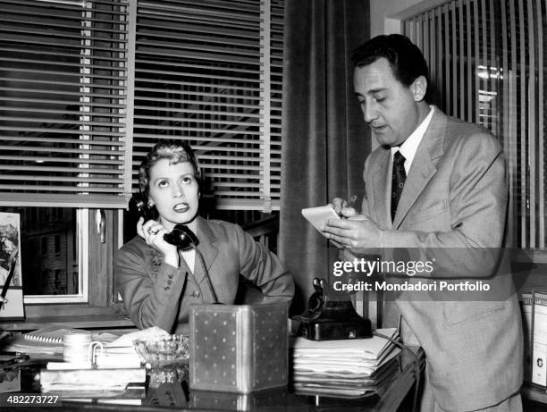 Italian actress and scriptwriter Franca Valeri speaking over the phone while Italian actor and director Alberto Sordi taking notes in the film A hero...