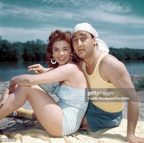 Italian actor and director Alberto Sordi and Italian actress Giovanna Ralli looking into the camera hugging each other in the film A hero of our...