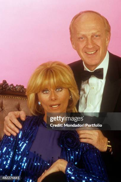 Italian actress and TV presenter Sandra Mondaini and her husband and Italian actor and TV host Raimondo Vianello looking into the camera seated in...