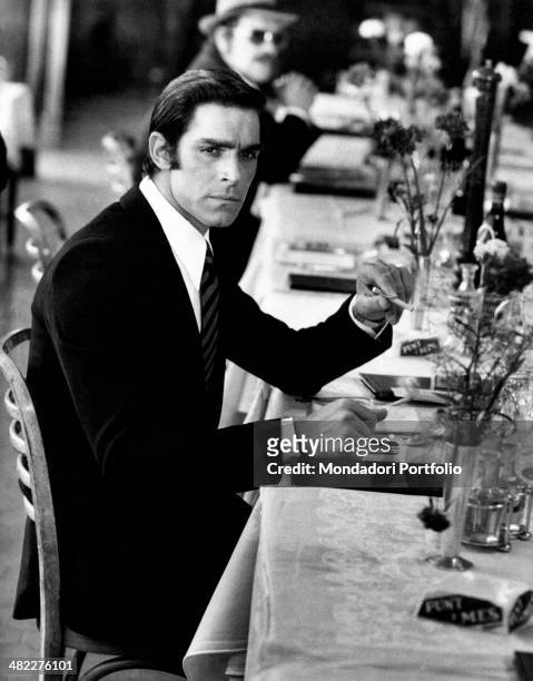 Italian actor and singer Fabio Testi and French actor Raymond Pellegrin sitting at the table of a restaurant in the film Gang War. Naples, 1972