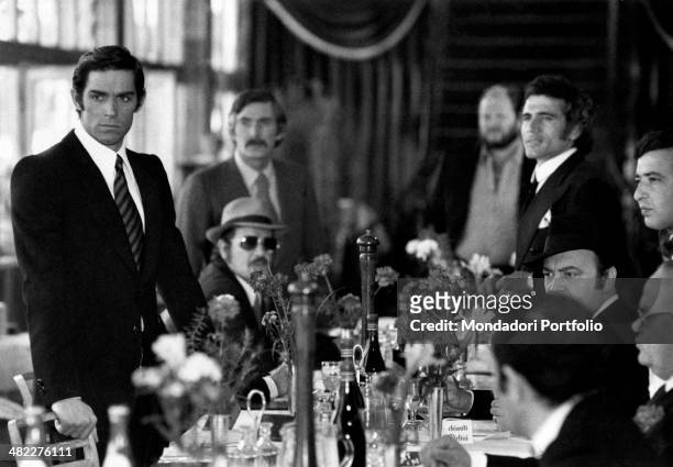 Italian actor and singer Fabio Testi and French actor Raymond Pellegrin sitting at the table of a restaurant in the film Gang War. Naples, 1972