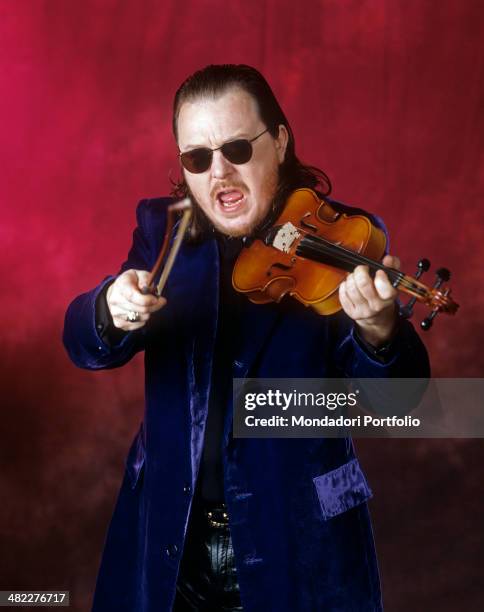 Portrait of Italian singer-songwriter and musician Zucchero holding a violin and wearing sunglasses. 1996