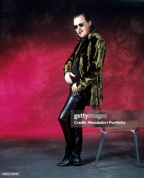 Italian singer-songwriter and musician Zucchero leaning on a chair in leather pants with a cigar in his mouth. 1996