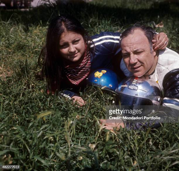 Patrizia Baldi caressing Italian singer and actor Claudio Villa in motorcycle suit. 1975