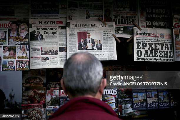 Man reads a newspaper showing Greek Finance Minister Yannis Stournaras, in Athens on April 2014. Europe needs a "New Deal" to rise above the economic...