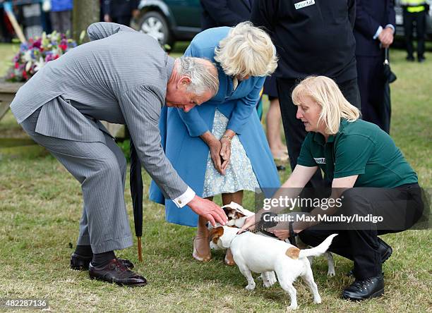 Prince Charles, Prince of Wales and Camilla, Duchess of Cornwall meet two Jack Russell dogs as they visit the Sandringham Flower Show on July 29,...