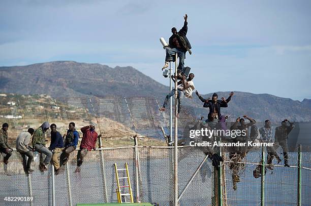 African migrants attempt to scale the fence at the border between Morocco and the North African Spanish enclave of Melilla, on April 3 in Melilla,...