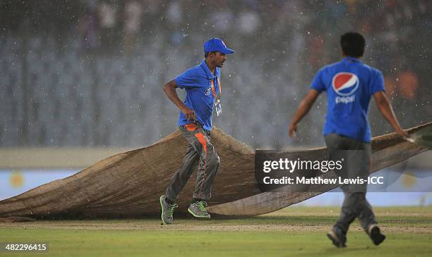 Groundsman cover the pitch with sheets, as heavy rain stops play during the ICC World Twenty20 Bangladesh 2014 Semi Final match between Sri Lanka and...