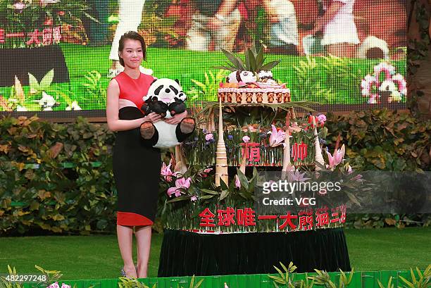Actress Myolie Wu poses with the cake during the ceremony for celebrating the only living panda triplets' 1st birthday at Chimelong Safari Park on...