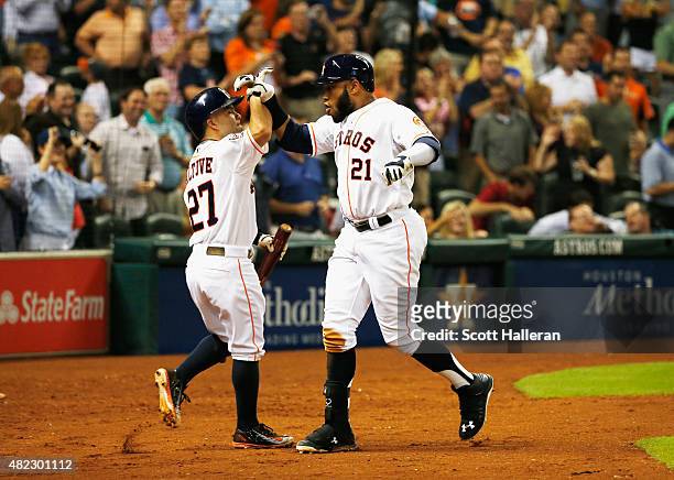 Jose Altuve and Jon Singleton of the Houston Astros celebrate after Singleton hit a solo home run against the Los Angeles Angels of Anaheim in the...