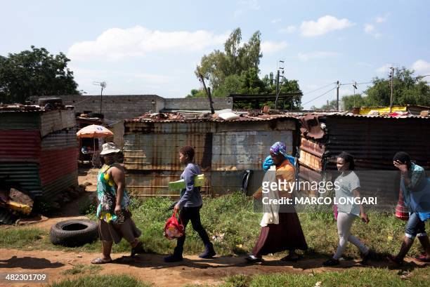 Wives of striking miners enter the impoverished informal camp just outside the South African Platinum hub of Marikana April 2, 2014. Government...
