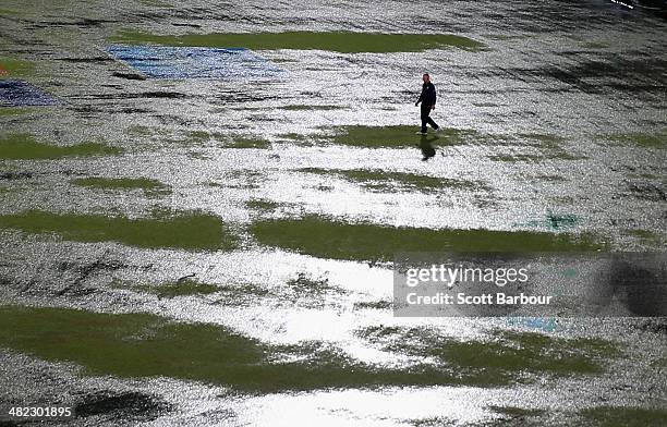 An umpire walks out to inspect the flooded field after heavy rain drenched the ground during the ICC World Twenty20 Bangladesh 2014 1st Semi-Final...