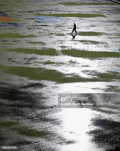 An umpire walks out to inspect the flooded field after heavy rain drenched the ground during the ICC World Twenty20 Bangladesh 2014 1st Semi-Final...