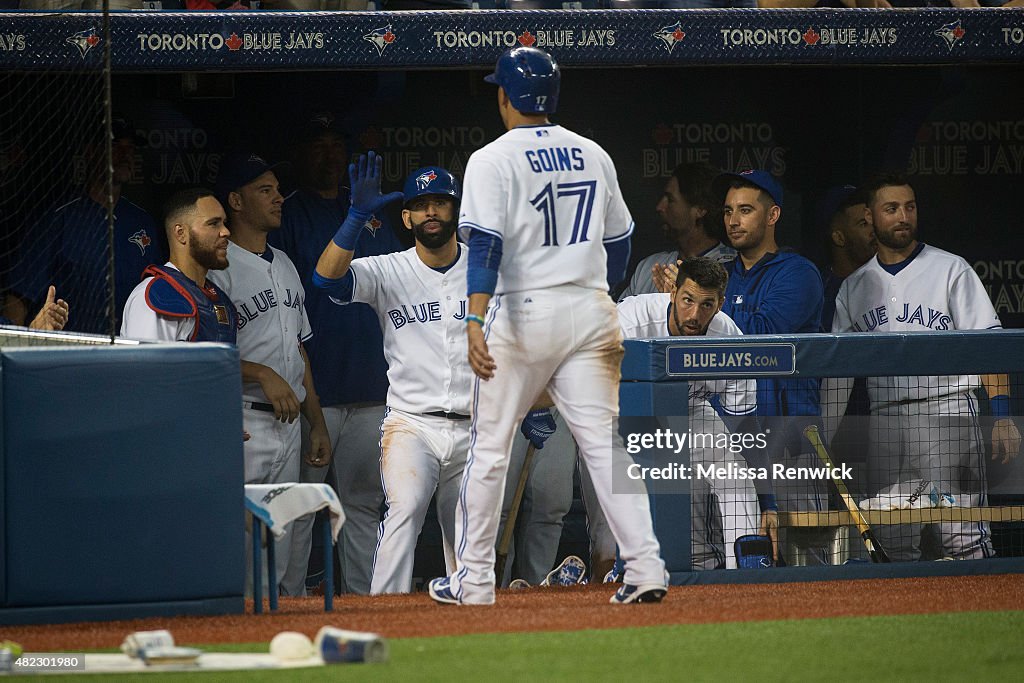 José Bautista congratulates Ryan Goins after scoring in the sixth inning during a Blue Jays game against the Philadelphia Phillies at the Rogers Centre.