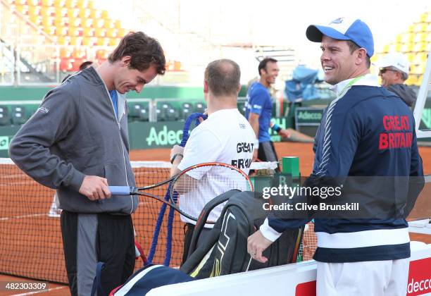 Andy Murray of Great Britain gets his racket ready for a late practice session watched by his team captain Leon Smith prior to the Davis Cup World...