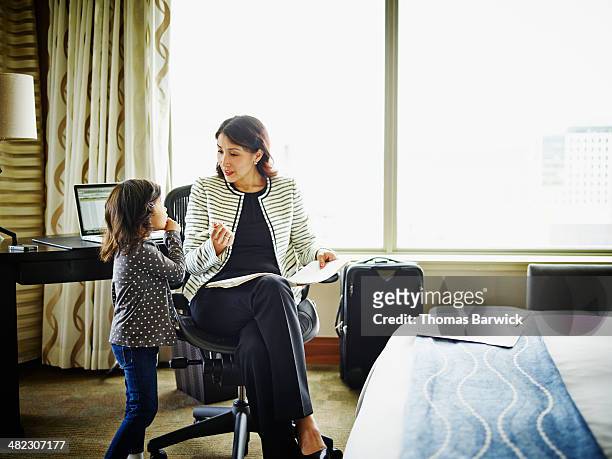 businesswoman in hotel room talking to daughter - leanincollection working mom stock-fotos und bilder