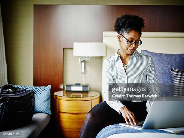 businesswoman in hotel suite working on laptop - välklädd bildbanksfoton och bilder