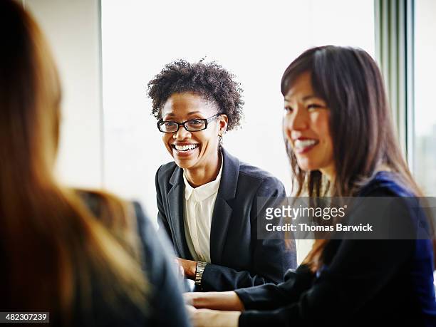 smiling businesswomen discussing project - thomas barwick meeting stock pictures, royalty-free photos & images