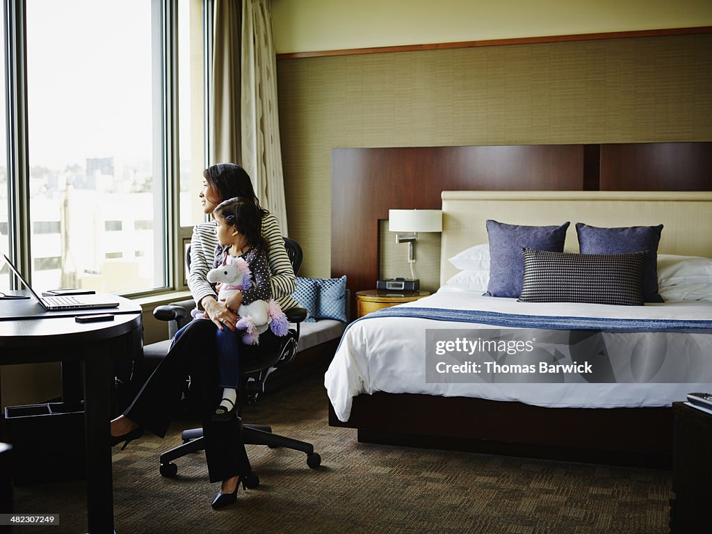 Businesswoman sitting with daughter in hotel room