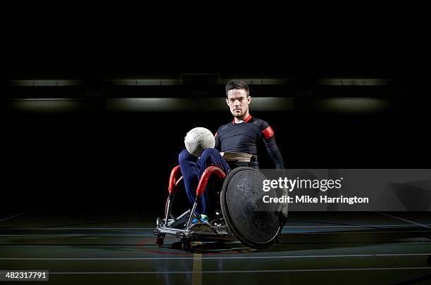 wheelchair rugby athlete in chair with ball - wheelchair rugby stock-fotos und bilder