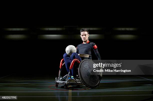 wheelchair rugby athlete in chair with ball - wheelchair rugby stockfoto's en -beelden