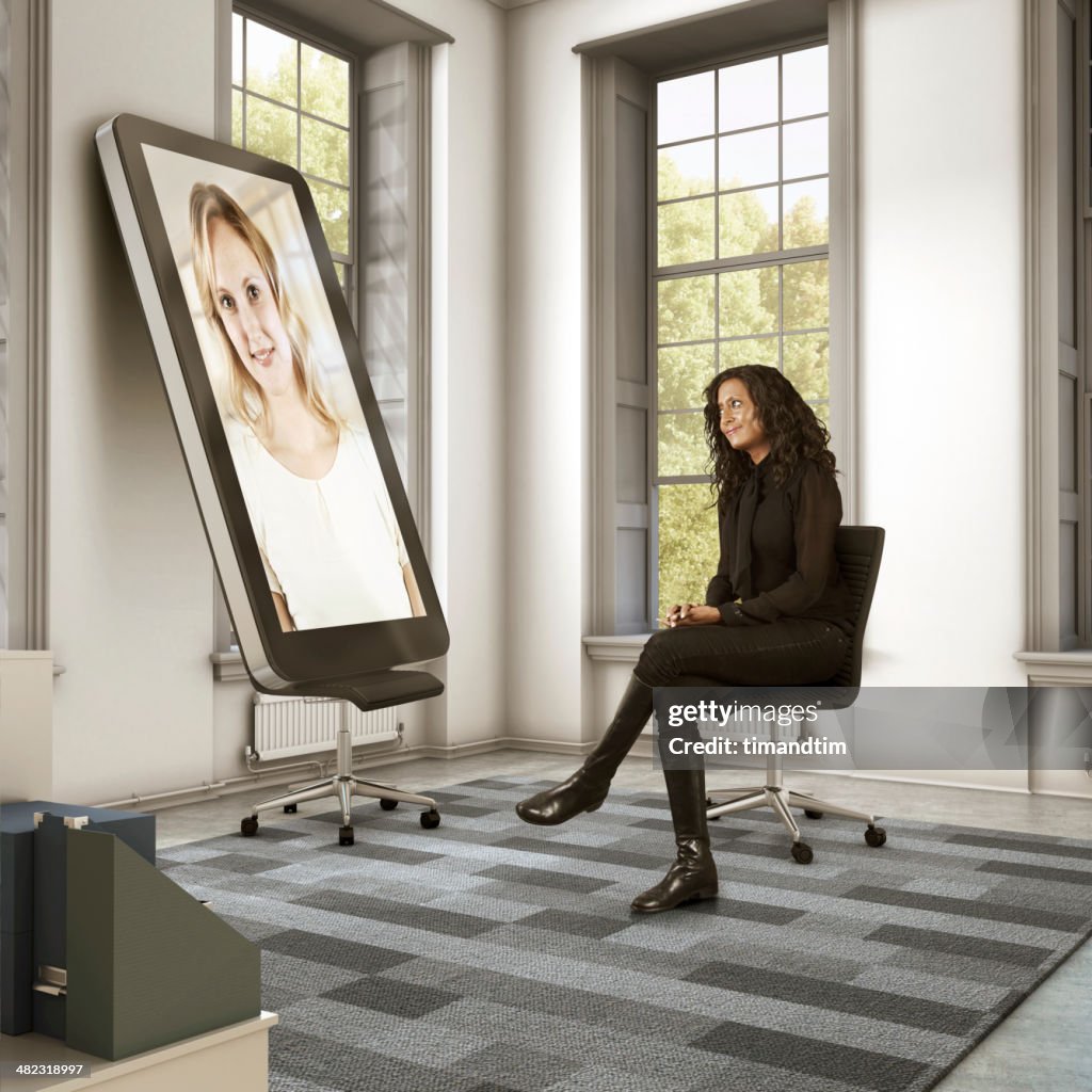 Two women talking through giant smartphone